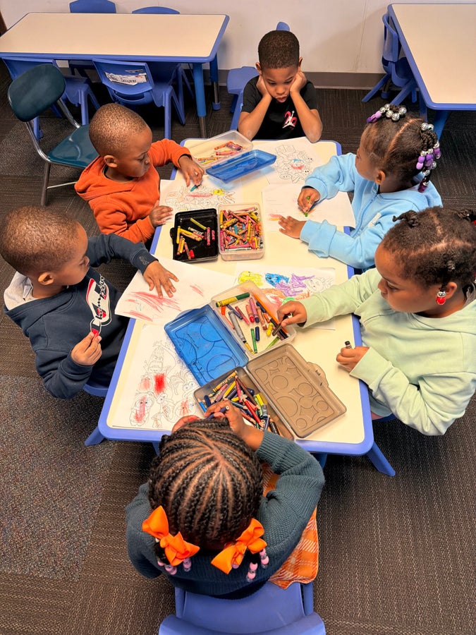 Children enjoying a creative learning activity together at Beanstalk Childcare