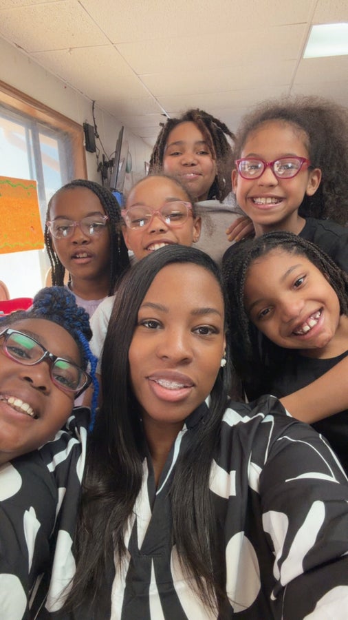 A Beanstalk educator smiling with children